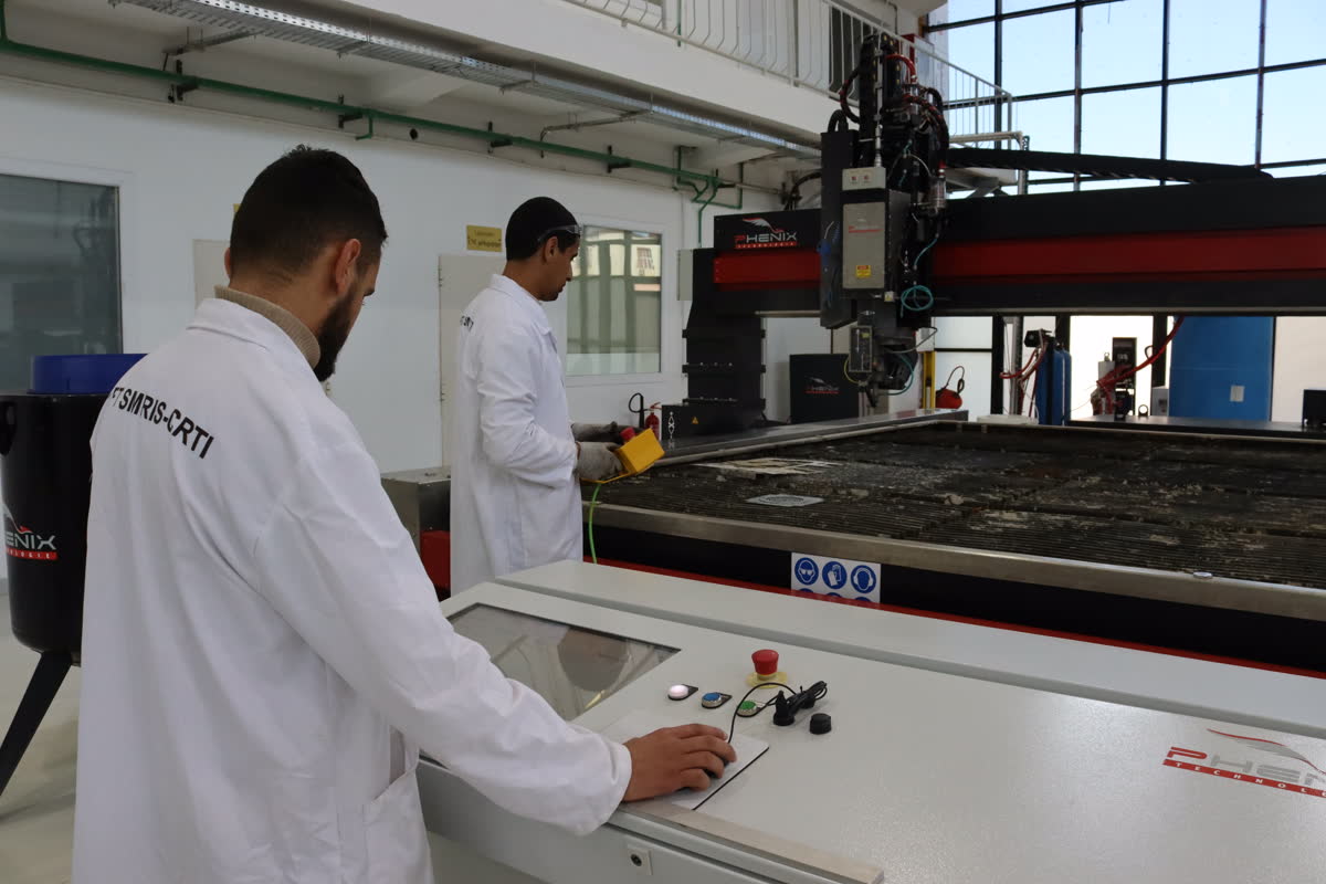 Techniciens sur la table de découpe jet d'eau